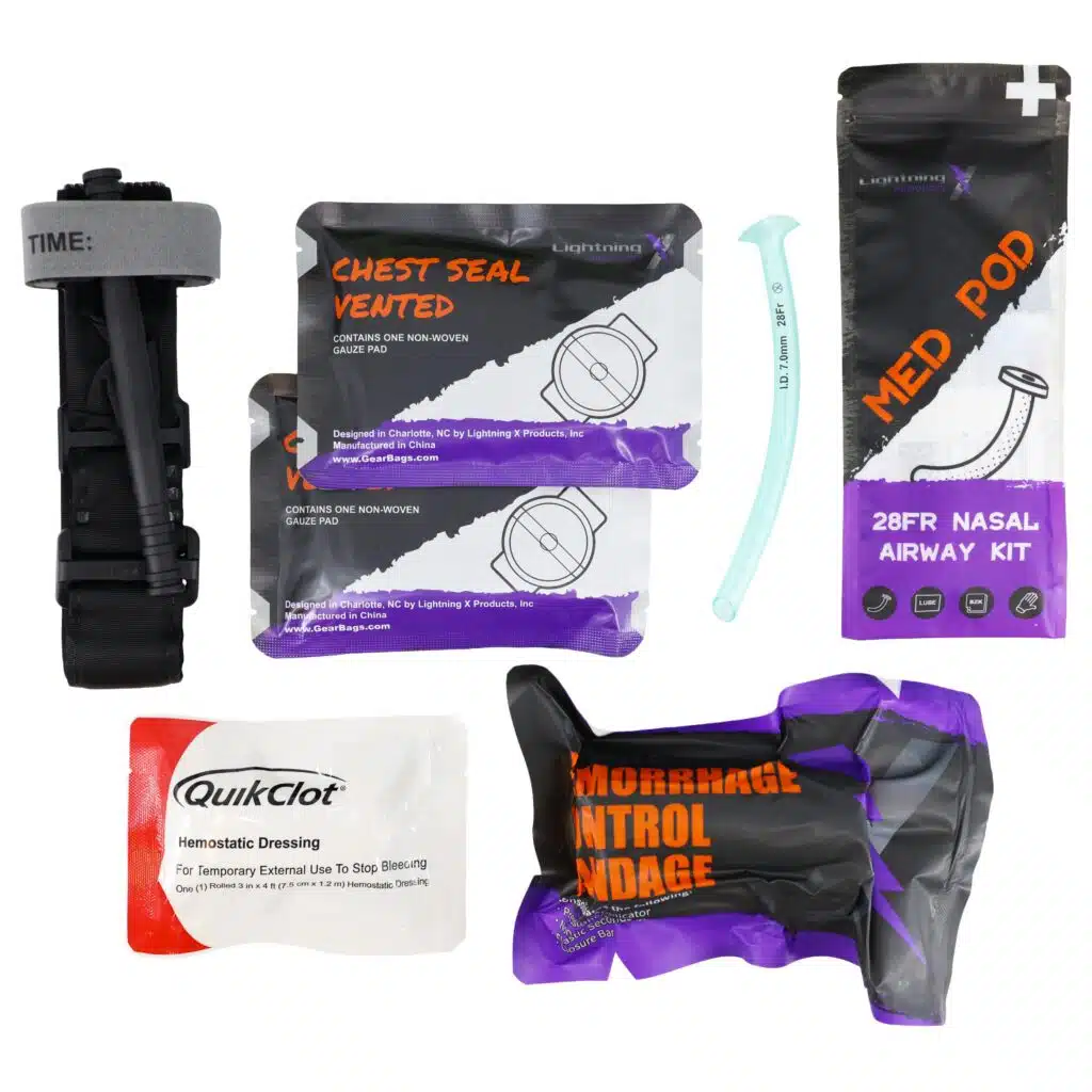 Flat-laid trauma kit: black tourniquet, vented chest seals, nasal airway, hemostatic dressing and hemorrhage bandage