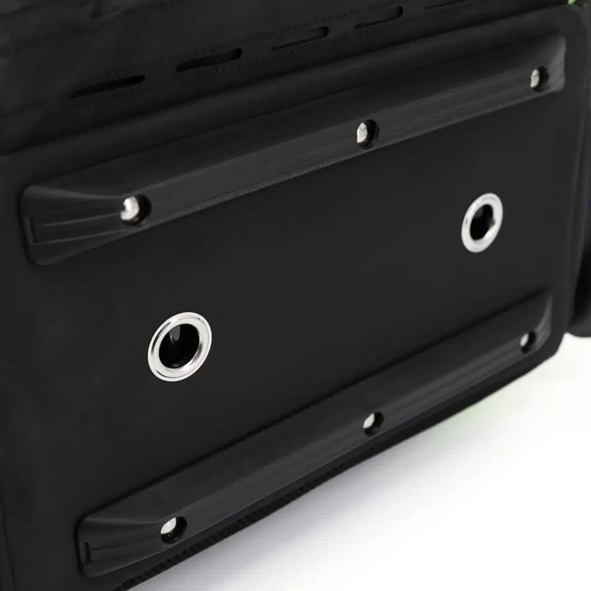 Black molded rubber skid feet and metal drainage grommets on the wipe-clean base of a tactical backpack