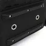 Black molded rubber skid feet and metal drainage grommets on the wipe-clean base of a tactical backpack