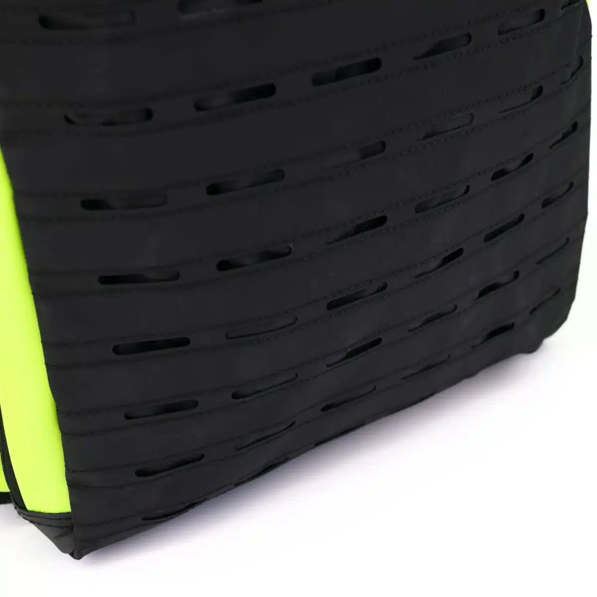 Black laser-cut MOLLE attachment panel with fluorescent yellow trim along the edge of a tactical backpack