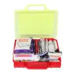 Red hi-vis hard-case first aid kit open, supplies organized in compartment trays under a translucent yellow lid