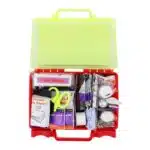 Red hi-vis hard-case first aid kit open, supplies organized in compartment trays under a translucent yellow lid