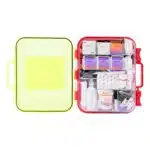 Red hi-vis hard-case first aid kit open, supplies in dual-layer swing-out trays under a translucent yellow lid