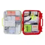 Red hi-vis hard-case first aid kit open, supplies in dual-layer swing-out trays under a translucent yellow lid