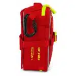 Red soft-shell first aid kit, side-profile view with the FIRST AID KIT print, carry handle, hi-vis zipper and MOLLE webbing