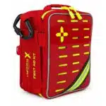 Red soft-shell first aid kit, three-quarter view showing the FIRST AID KIT side print, hi-vis cross and MOLLE slots