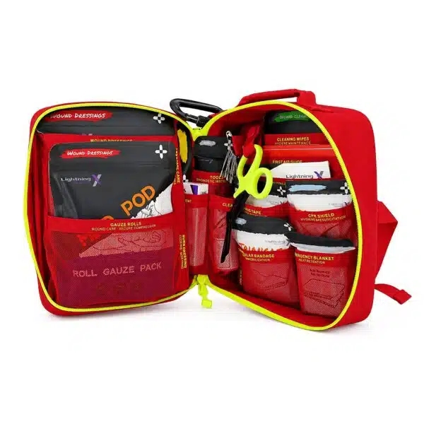 Red soft-shell first aid kit laid open, showing organized medical supplies in labeled mesh pockets and loops