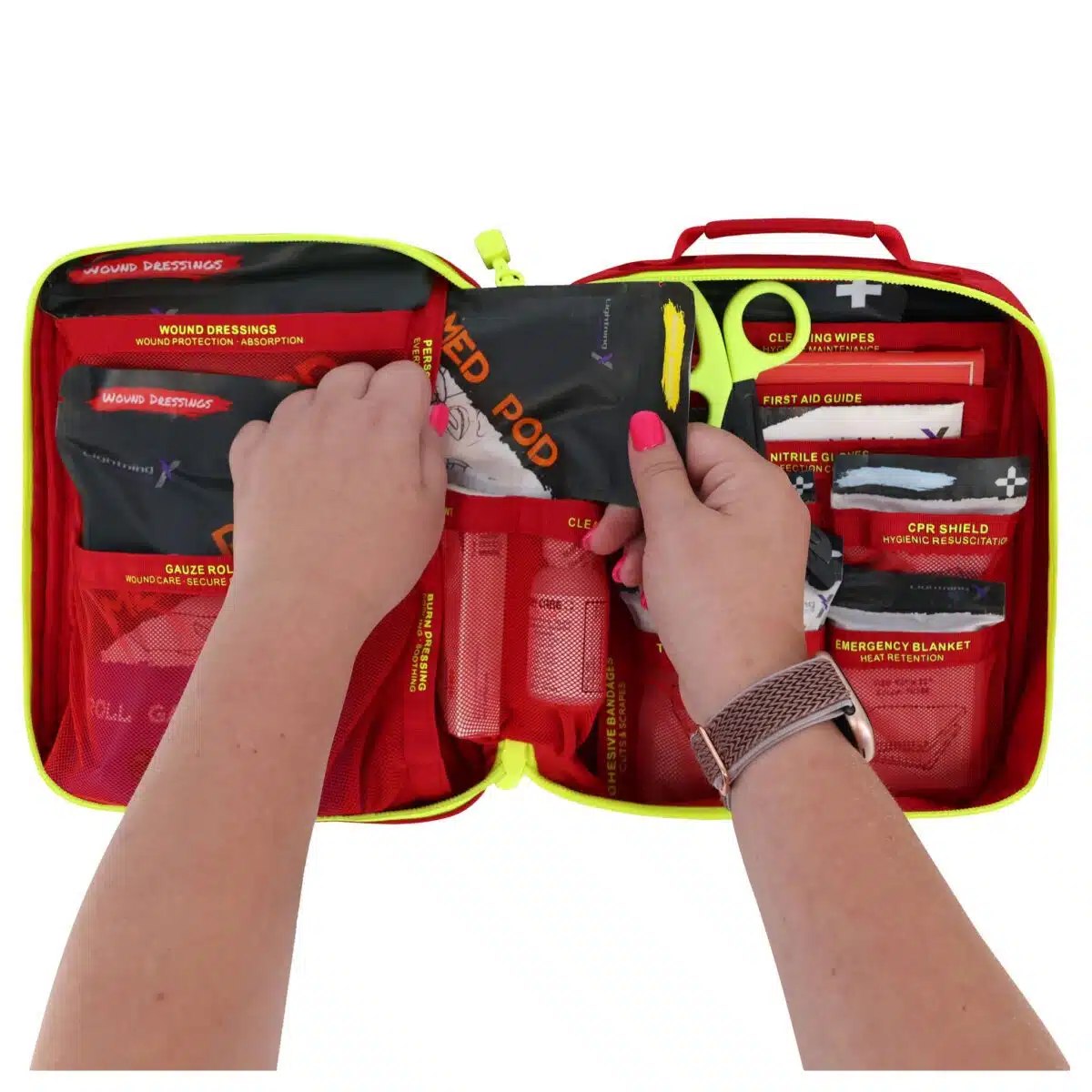 Hands lifting a color-coded pouch from an open red soft-shell first aid kit filled with labeled supplies