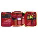 Red soft-shell first aid kit opened flat, showing organized medical supplies behind labeled mesh pockets