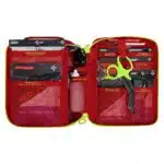Red soft-shell first aid kit, open interior of color-coded pouches and supplies in labeled mesh pockets